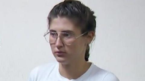 Bella Culley filmed in court. She is wearing glasses and has brown hair in a plait and is wearing a white top