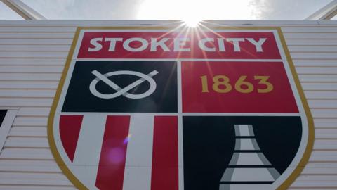 A picture of Stoke City's new club crest. A shield showing a Staffordshire knot, the club's foundation date of 1863, their red and white stripes, and a kiln.