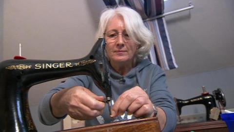 Nikki Field repairing a black Singer sewing machine