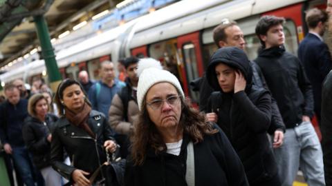 Commuters leave a Tube train