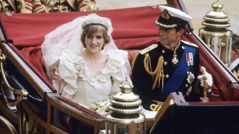 King Charles and Diana in her wedding dress on their wedding day in a chariot.