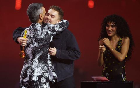 Sam Fender receives an award for Song of the Year from Robbie Williams, next to Olivia Dean during the BRIT Awards at the Co-op Live Arena, in Manchester. 