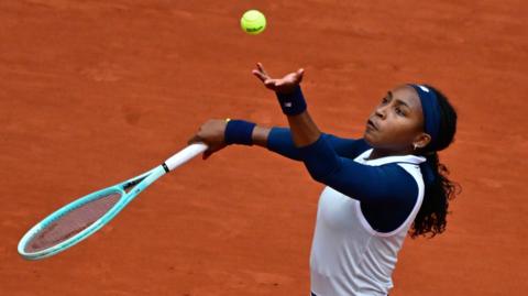 Coco Gauff throws the ball to serve