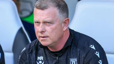 Mark Robins looks on from the dugout during a Stoke City match