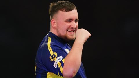 Luke Littler celebrates winning a leg against Ian White in the third round of the PDC World Darts Championship