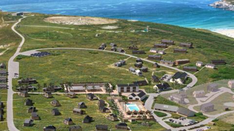 An aerial view of a number of holiday lodges with the sea in the distance