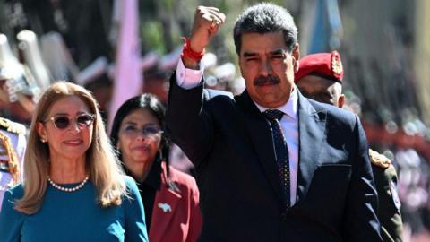 Venezuela's President Nicolas Maduro (R) gestures next to First Lady Cilia Flores on arrival at the Capitolio -house of the National Assembly- for the presidential inauguration, in Caracas on January 10, 2025