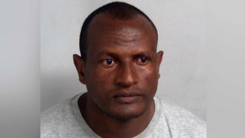 Kebatu, in a grey top, looks to the right of frame