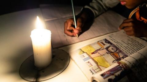 Boy studying by candlelight