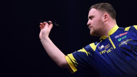 Luke Littler throws a dart
