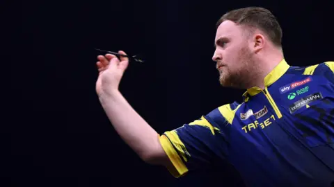 Luke Littler throws a dart
