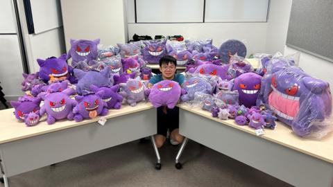 Tsang Cheuk Tip surrounded by Gengar toys.