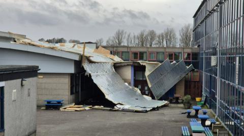 The roof of the school has been torn off and is lying in pieces in the playground