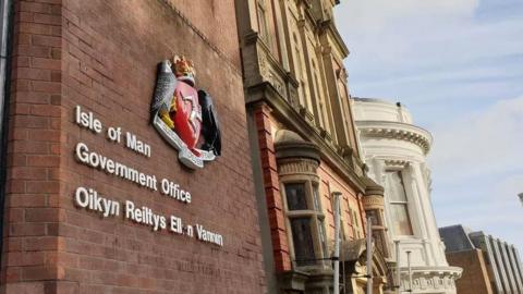 The exterior of the Isle of Man Government building, a sign reads Isle of Man Government Office.