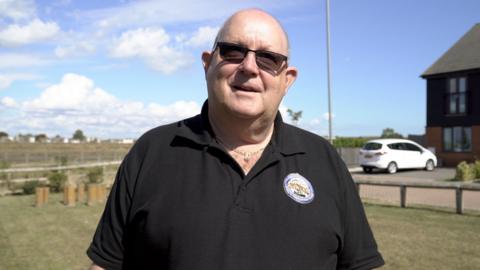 Co-director of the Queenborough Phase One in the Isle of Sheppey, Neil Shrubsole, is standing near the estate. 