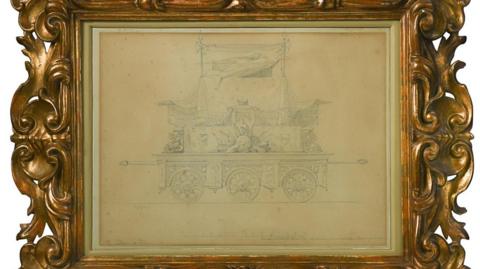 The design for a funeral carriage. It has been drawn in pencil and has been framed with a gold frame. It has been placed on a white background.