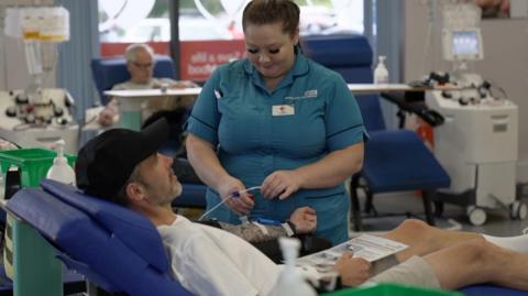 Nurse with man who is donating blood