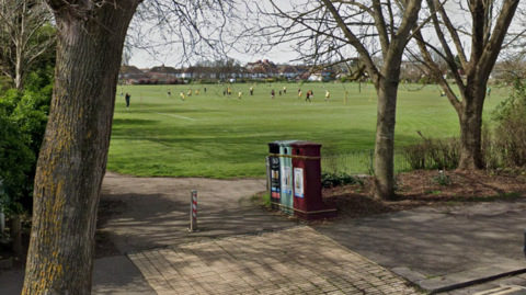 A google maps image of Wish Park, Hove, East Sussex. There is a number of people playing on the grass, with trees in the foreground. 