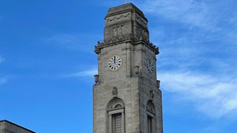 Barnsley Town Hall's clock tower: a tall, slim building in white stone with a clock face displayed on all four sides of the tower