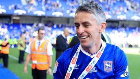 McKenna smiles into the crowd with a medal around his neck during celebrations of Ipswich Town's promotion to the Premier League in May 2026