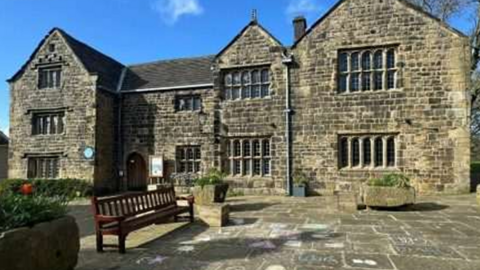 A stone fronted large manor house.