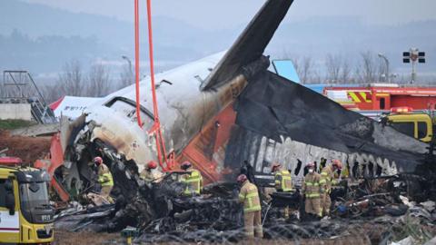 Firefighters and recovery teams work at the scene where a Jeju Air Boeing 737-800 series aircraft crashed and burst into flames at Muan International Airport in Muan, some 288 kilometres southwest of Seoul on December 30, 2024