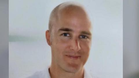 A head and shoulders picture of Alexander Cashford shows a balding man wearing a white shirt, smiling at the camera.