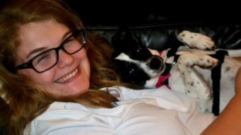 A headshot of Kerry Wright smiling and holding a dog