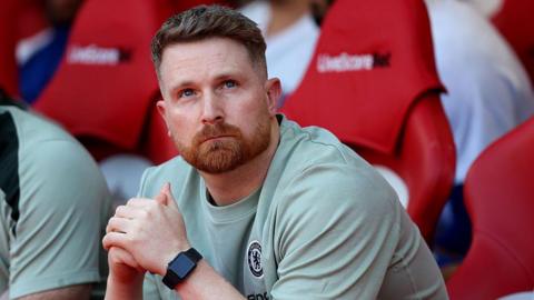 Calum McFarlane clasps his hands together on Chelsea's bench