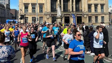 Runners in last year's race passing Hull's Guildhall cheered on by spectators