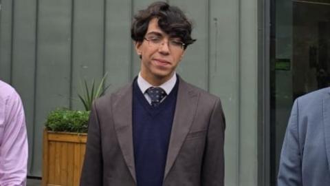 Mohamed Amine Mokrane, with glasses and dark hair, wearing a suit 