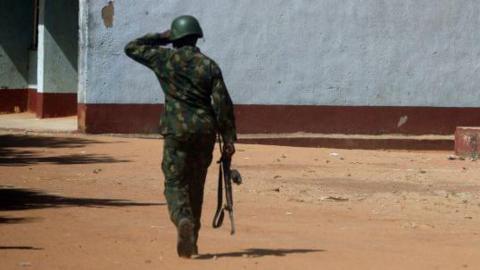 An armed soldier guarding a compound