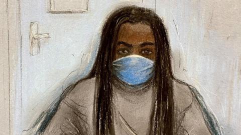 A sketch of the defendant, who is wearing a face mask and jumper.