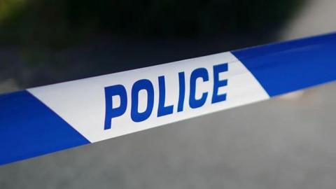 A close up image of blue and white tape with the word police written on it