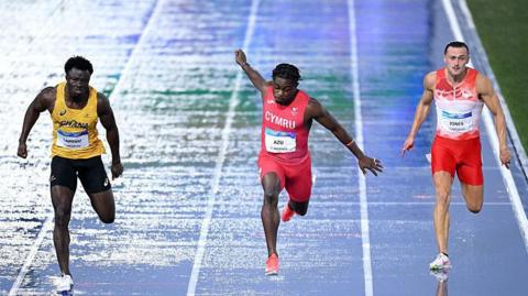 Abdul-Rasheed Saminu of Team Ghana, Jeremiah Azu of Team Wales and Elliot Jones of Team England compete in the Men's 100 Metres Semi-Finals 
