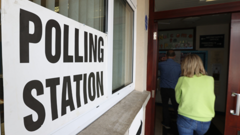 A woman queues up at a polling station 