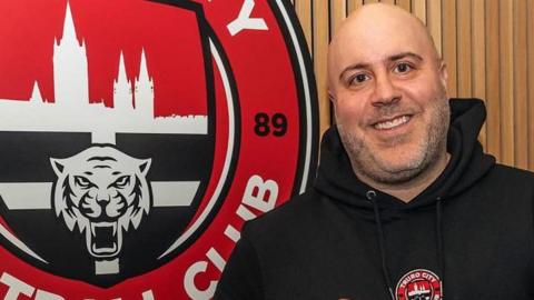 Eric Perez beside a Truro City sign