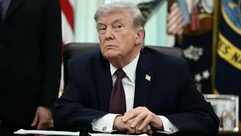 US President Donald Trump takes a question from a reporter after signing an executive order in the Oval Office of the White House in Washington