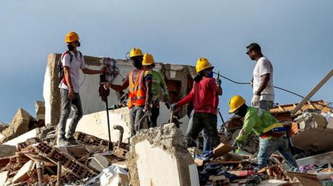 Members of the French Civil Security Training and Intervention Regiment (UIISC 7) help residents in the search for victims