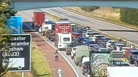 A CCTV image of the closed part of the M6 with cars parked up and people walking around the carriageway