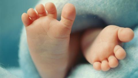 Close up of baby's feet on a blue blanket 