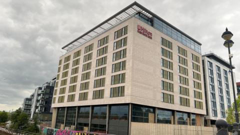 Large hotel with Hilton branding next to river in Peterborough 