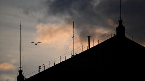 Silhouette of the chimney on the Sistine Chapel as the sun sets