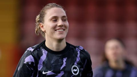 Brighton & Hove Albion Women captain Maisie Symonds running in a black and purple Albion training shirt. 