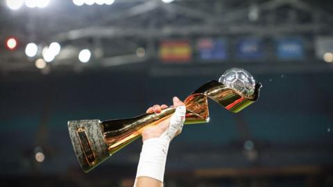 A player holds up the women's world cup trophy