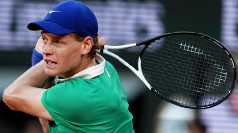 Jannik Sinner hits a backhand