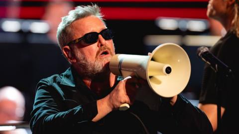 Guy Garvey holding up a megaphone