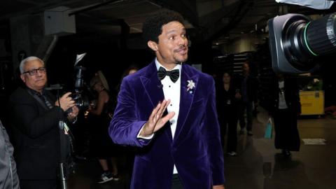Trevor Noah wearing a purple suit at the Grammys.