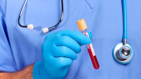 Doctor holding a blood sample for testing