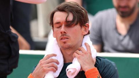 Alex de Minaur with towel around his neck and eyes closed